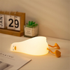 une veilleuse canard en position allongée sur un bureau afin d'illuminer la pièce.
